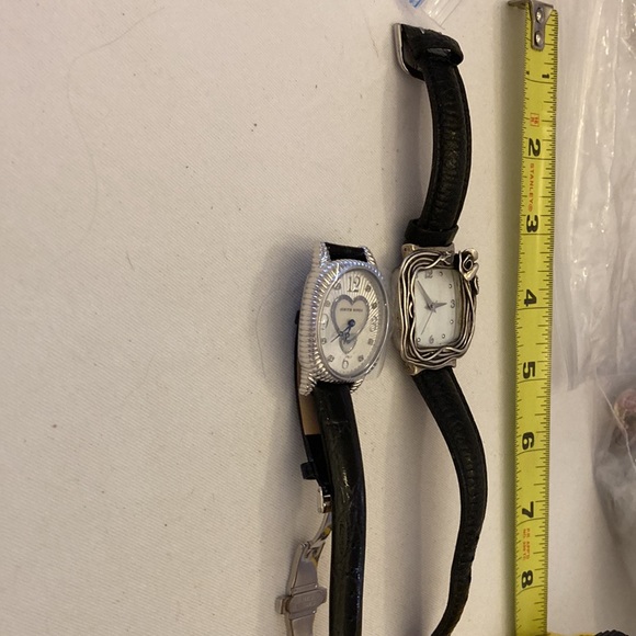 2 designer watches with black leather bands.